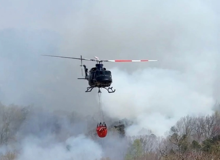 Helicopter dropping water of wildfire