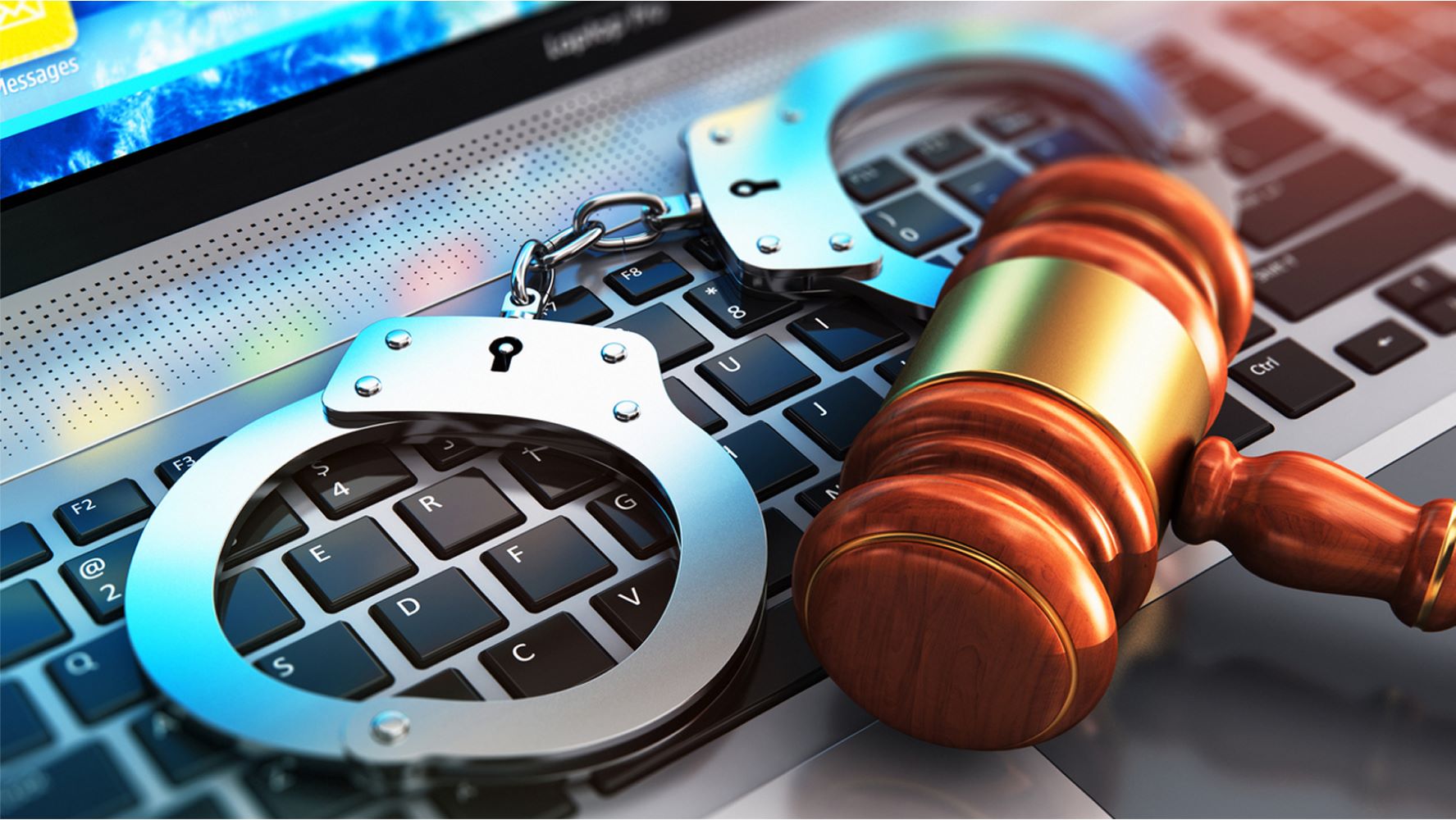 Handcuffs and gavel on top of a laptop keyboard image