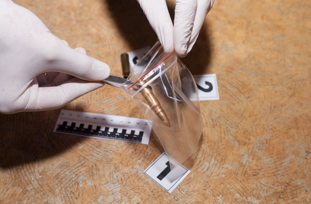 Gloved hands collecting evidence